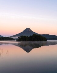 Serene mountain reflected in calm lake at dawn