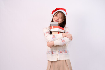 young charming woman wearing santa hat holding present boxes celebrating christmas in white studio background