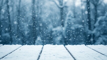 Fototapeta premium Snow-covered wooden surface with falling snowflakes, evoking a serene winter atmosphere.