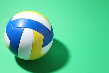 Fototapeta premium Colorful volleyball ball on green background. Space for text