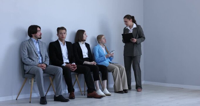 People waiting in queue on chairs indoors