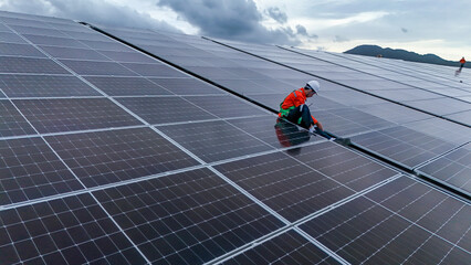 Engineers or technicians in safety gear meticulously inspecting and maintaining large-scale solar...