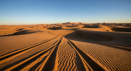 vast desert sand dunes tire tracks golden hour light