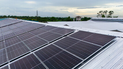 A commercial-scale photovoltaic (PV) solar array installed on an industrial building's roof. This renewable energy system feeds clean electricity directly into the power grid.