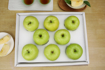 Fresh Green Apples in White Gift Box on Wooden Table Top View