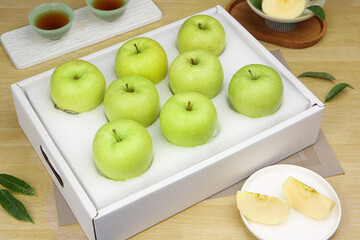 Fresh Green Apples in White Gift Box with Tea Service on Wooden Table