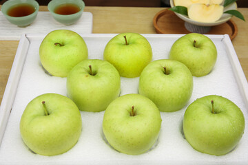 Fresh Green Apples in White Wooden Box with Tea Setting