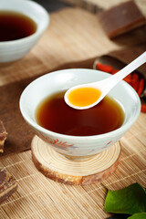Ginger Tea with Brown Sugar in Ceramic Bowl on Bamboo Mat - Traditional Herbal Drink