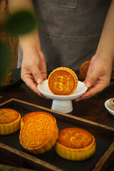 Traditional Handmade Cantonese Mooncakes with Five Kernel and Lotus Seed Paste Fillings on Ceramic Stand