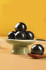 Handmade Black Sesame Balls Ready to Eat Traditional Asian Dessert Closeup on Yellow Background