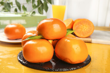 Fresh Sweet Persimmons from Fuping on Slate Plate with Orange Juice