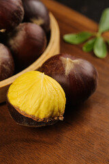 Fototapeta premium Fresh Chestnuts with Golden Kernels on Wooden Background - Natural Autumn Nuts