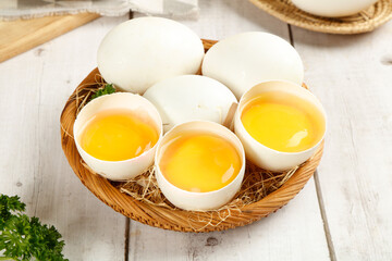 Fresh Farm Eggs in Rustic Basket with Golden Yolks on White Wood Table