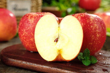 Fresh Red Apples Cut in Half on Wooden Board with Mint Leaves