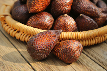 Fresh Bali Snakeberry Fruits in Wicker Basket - Exotic Imported Tropical Produce on Wooden Background
