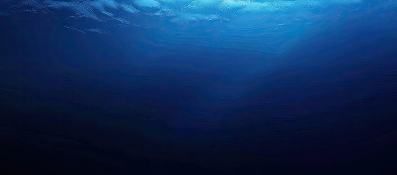 Deep ocean scene showing a gradient of blue hues, from lighter blue at the top to deep, dark blue at the bottom, suggesting depth and the absorption of light in water