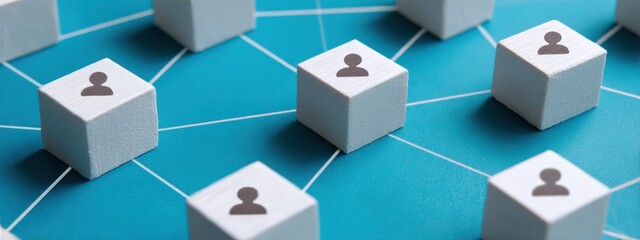 Obraz premium Wooden cubes representing users connected by a network on a blue background, symbolizing global communication and teamwork