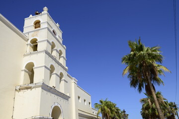 Church and Mission of TODOS SANTOS in the municipality of La Paz, Baja California Sur, Mexico, on a sunny summer morning with palm trees on teh  side, and blue sky in the background