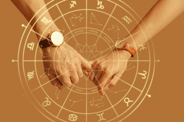 Couple with wristwatches holding pinkies on brown background