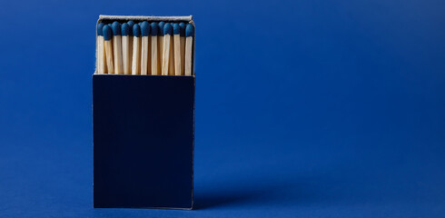 Box with new matches on blue background