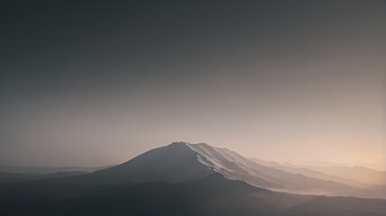 Serene mountain range at dawn with soft light and atmospheric haze, evoking peace and tranquility
