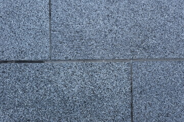 People walking on polished wooden floor with dramatic sunlight reflections from glass windows, creating abstract shadow and light patterns in a modern architectural interior.