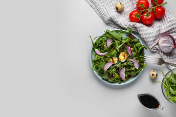 Plate with tasty arugula salad and ingredients on white background