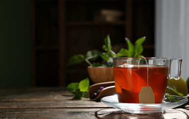 Cup of tasty hot tea on wooden table, closeup