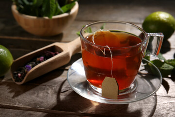 Cup of tasty hot tea on wooden table, closeup