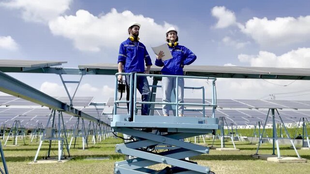 Team works on solar panel installation at a large solar farm during bright day