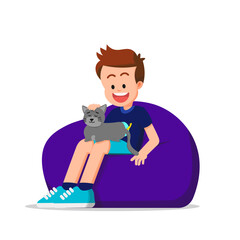 A boy sits on a beanbag with a sleeping cat on his lap