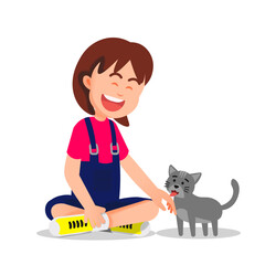 A little girl sits on the floor, giggling softly as a cat licks her hand