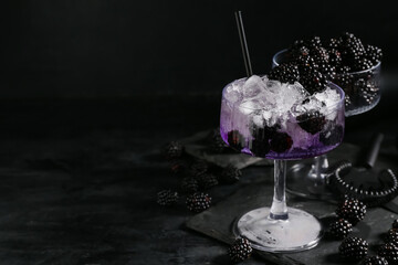 Tray, glasses with tasty cool blackberry lemonade and ingredient on black background, closeup