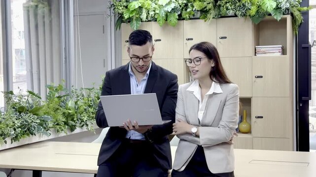 Two people discuss project ideas in a bright office space during work hours