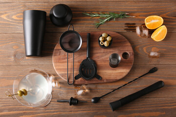 Different bartender utensils and cocktail ingredients on wooden background