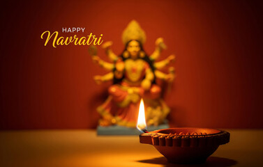 Navratri poster-Realistic minimalistic poster of a diya with glowing flame placed in the foreground, blurred idol of Maa Durga in the background, bold text ‘Happy Navratri’