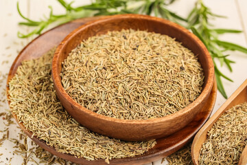 Bowls with dried rosemary on white wooden background, closeup