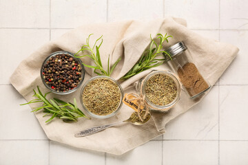 Bowls with dried rosemary and black peppercorns on white tile background