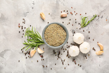 Bowl with dried rosemary on grey grunge background