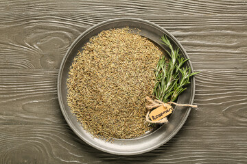 Bowl with dried and fresh rosemary on grey wooden background, closeup