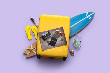 Composition with suitcase, passport, surfboard, world map and photo camera on lilac background