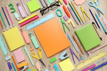 Notebook, eyeglasses and different school stationery on wooden background