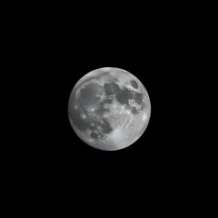 Fototapeta premium A large, round, dark moon in the sky. The moon is the only object in the image. 