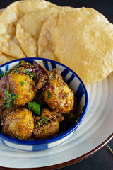 Traditional Bengali bhaja masala aloo dum served with dal puri, authentic Indian festive meal, spicy potato curry paired with lentil stuffed puri, popular Bengali breakfast and celebration thali
