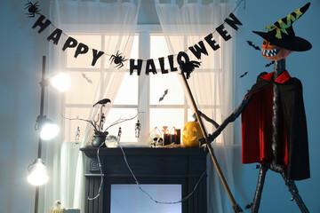 Interior of living room decorated for Halloween with scarecrow, fireplace and glowing lamp in evening