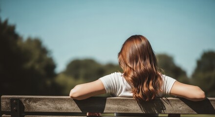 Back of woman resting on park bench