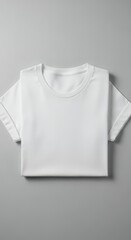 Clean white t-shirt folded neatly on a neutral gray background, perfect for design mockups