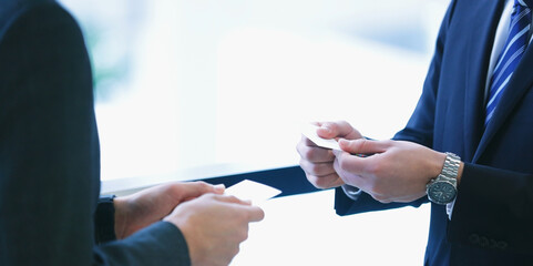 Business deal betwwen two atakeholders or two companies or two people shaking hands and exchange of businesscards or visiting cards