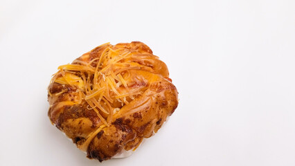 A single braided bread with shredded cheddar cheese topping isolated on white background with copy space