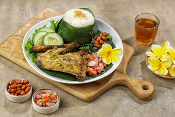 Nasi Ayam Betutu. Betutu Chicken Rice served with plecing kangkung and sambal matah